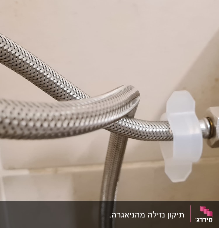 צינור מתכת מחובר לאסלה עם חיבור פלסטיק